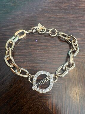 GUESS Gold Tone Charm Bracelet with Crystal Accents and Logo Charms